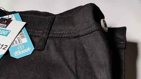 Central Java Indonesia 2 March 2026: New black pants with brand label attached,  Video stock 330807990
