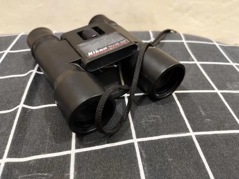 Central Java Indonesia 22 may 2026: Binoculars on a bed in a close-up view Stock Photos