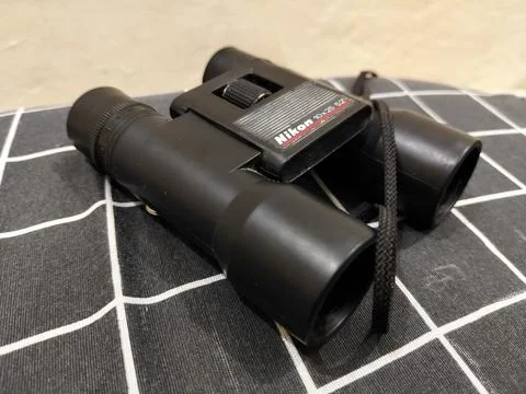Central Java Indonesia 22 may 2026: Binoculars on a bed in a close-up view Stock Photos