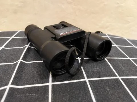 Central Java Indonesia 22 may 2026: Binoculars on a bed in a close-up view Stock Photos