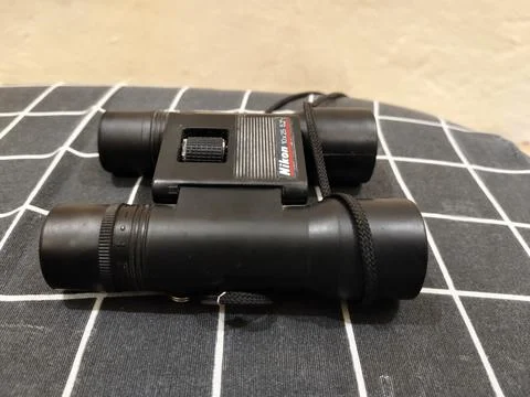 Central Java Indonesia 22 may 2026: Binoculars on a bed in a close-up view Stock Photos