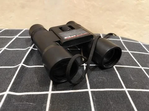 Central Java Indonesia 22 may 2026: Binoculars on a bed in a close-up view Stock Photos