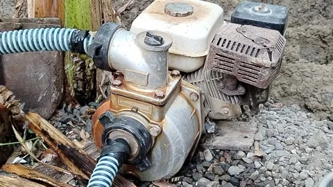Central Java Indonesia 27 July 2026: Portable gasoline-powered water pump connec Stock Footage 340898278