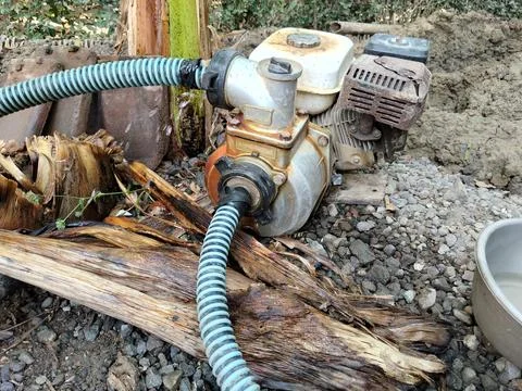 Central Java Indonesia 27 July 2026: Portable gasoline-powered water pump connec Stock Photos