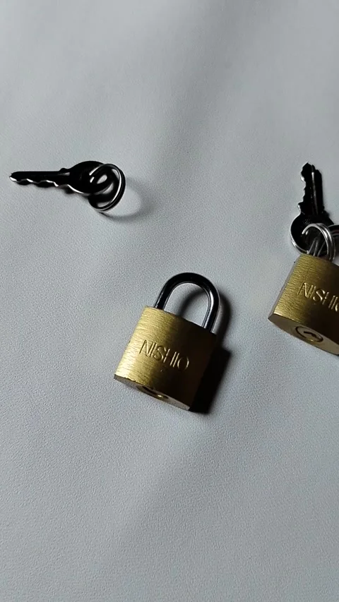 Central Java Indonesia 5 may 2026: Metal padlock key isolated on plain backgroun Vídeos de archivo 334326025