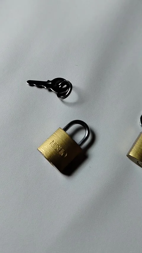Central Java Indonesia 5 may 2026: Metal padlock key isolated on plain backgroun Vídeos de archivo 334326026