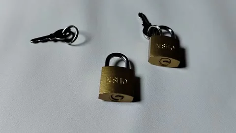 Central Java Indonesia 5 may 2026: Metal padlock key isolated on plain backgroun Vídeos de archivo 334326027