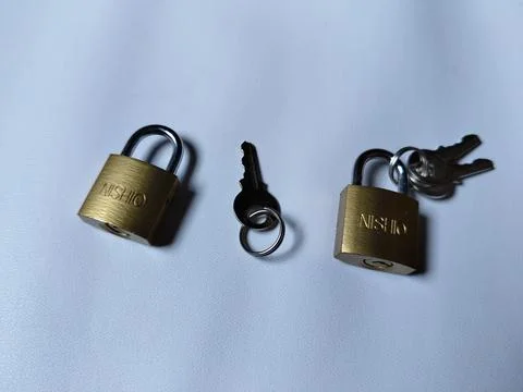 Central Java Indonesia 5 may 2026: Metal padlock key isolated on plain backgroun 写真素材