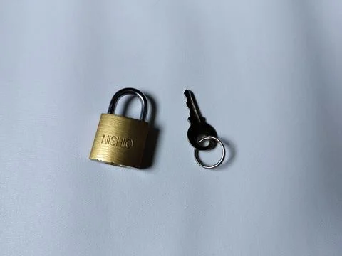 Central Java Indonesia 5 may 2026: Metal padlock key isolated on plain backgroun 写真素材