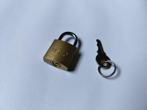 Central Java Indonesia 5 may 2026: Metal padlock key isolated on plain backgroun Stock Photos