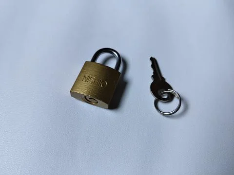 Central Java Indonesia 5 may 2026: Metal padlock key isolated on plain backgroun 写真素材