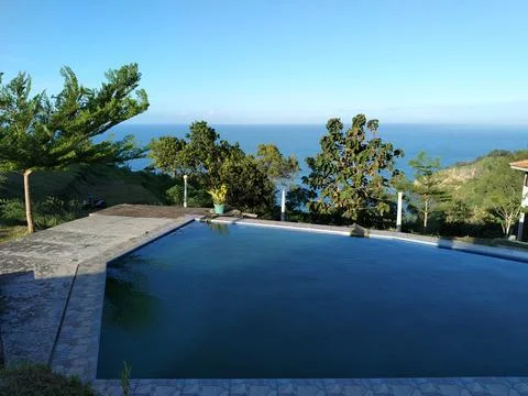 Central Java Indonesia 6 March 2026: Tropical poolside with stunning Indian Ocea 스톡 사진