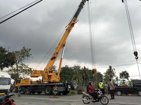 Central Java Indonesia 9 april 2026: Crane truck lifting a fallen cement tanker  Fotos de archivo