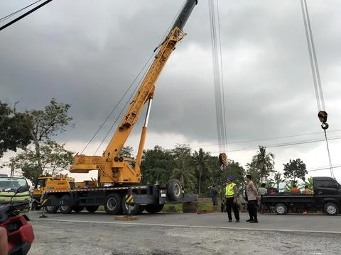 Central Java Indonesia 9 april 2026: Crane truck lifting a fallen cement tanker  Fotos de archivo
