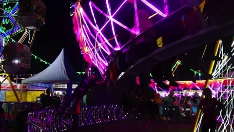 Central Java, Indonesia. April 15,2024: Slowmo attractions on rotating ride Stock Footage 274828760