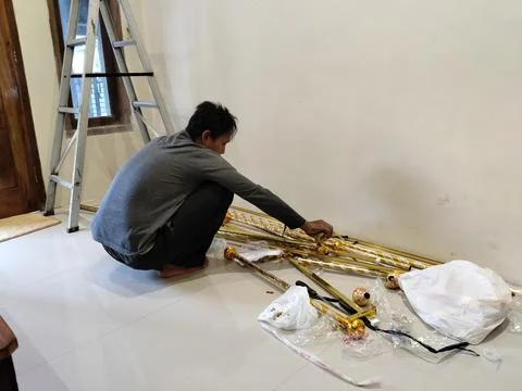 CENTRAL JAVA, INDONESIA - AUG 09, 2026: An Asian man squatting on a tile floor p Stock Photos
