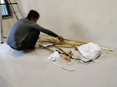 CENTRAL JAVA, INDONESIA - AUG 09, 2026: An Asian man squatting on a tile floor p Stock Photos