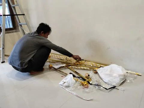 CENTRAL JAVA, INDONESIA - AUG 09, 2026: An Asian man squatting on a tile floor p Stock Photos