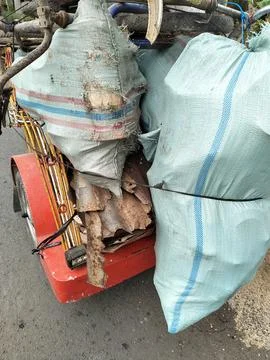 CENTRAL JAVA, INDONESIA - AUG 14, 2026: A heavily loaded modified motorcycle tri Stockfoto's