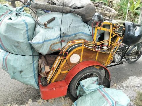 CENTRAL JAVA, INDONESIA - AUG 14, 2026: A heavily loaded modified motorcycle tri 写真素材