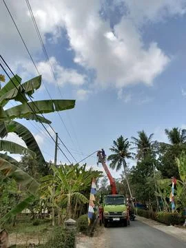 Central java Indonesia, AUG 22, 2026: A utility worker in a bucket truck repairi Stock-Fotos