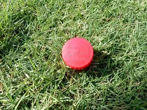 Central Java, Indonesia August 17, 2024: Coca cola bottle cap, on grass backgrou Foto stock