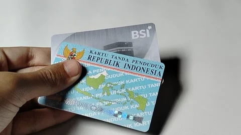 Central Java Indonesia February 15, 2026: A person holding an ID card and a BSI  스톡 동영상 329205368