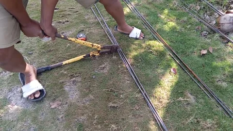 Central Java Indonesia July 11, 2025: a is cutting a concrete iron rod, building Stock Footage 313578356