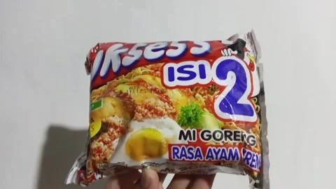 Central Java Indonesia June 6, 2025: a person holding Suksess instant noodles. 動画素材 311520202