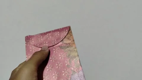 Central Java, Indonesia, March 24, 2026: A person holds a red envelope, a  gift  Stock Footage 332159515