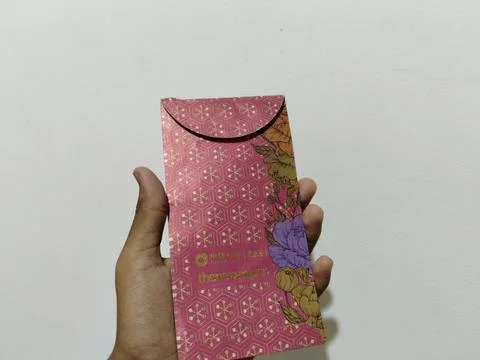 Central Java, Indonesia, March 24, 2026: A person holds a red envelope, a  gift  Stock Photos