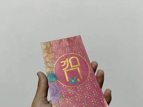 Central Java, Indonesia, March 24, 2026: A person holds a red envelope, a  gift  Stock Photos