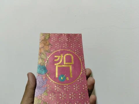 Central Java, Indonesia, March 24, 2026: A person holds a red envelope, a  gift  Stock Photos