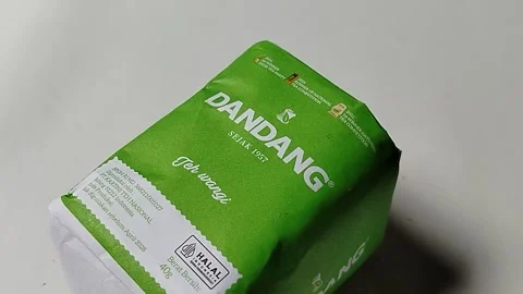 Central Java, Indonesia, May 19, 2026: Unopened green paper packaging of Dandang Vídeos de archivo 335191877