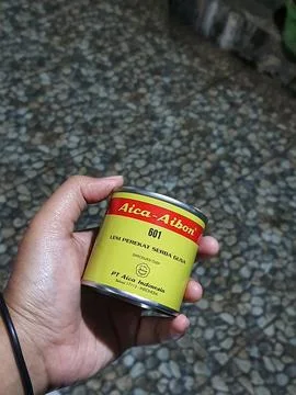 Central Java, Indonesia in October 2022. A hand holding Aica Aibon glue. Fotos Stock