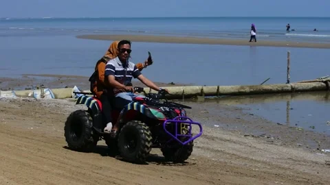Central java, Indonesia -September 2, 2022: visitors ride ATV on beach, Stock Footage 214289369