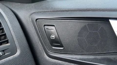 Central locking button is pressed on a car dashboard, vehicle door lock control, Stock Footage 337114732