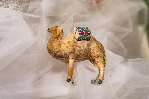 Central paper camel adorned with patterns, jewel headpiece, soft lace backdro Stock Photos