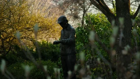 Central park bronze statue checking time at sunset near reservoir Stock Footage 229331759