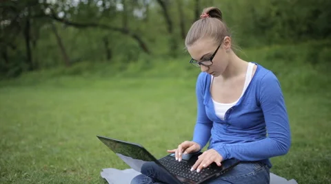 In the central park sitting on the grass young girl working on laptop Stock Footage 62844942