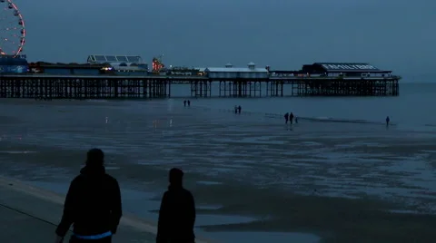 Central pier at dusk tide out people walking by Stock Footage 48483473