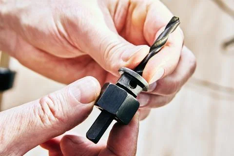 Central pilot bit and drill attachment held in hands, showing key component.. 写真素材
