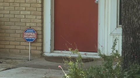 Central Security Texas sign in front of red door in residential area suburban Vídeo Stock 113598945