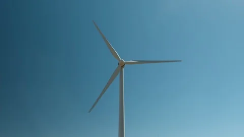 Central shot looking directly at wind tower rotating against a blue sky - HD. Stock Footage 87888050