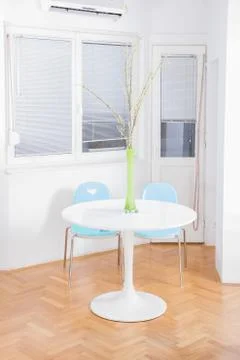Central table with flower in front of windows Stock Photos