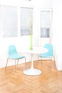 Central table with flower in front of windows in dining room Stock Photos