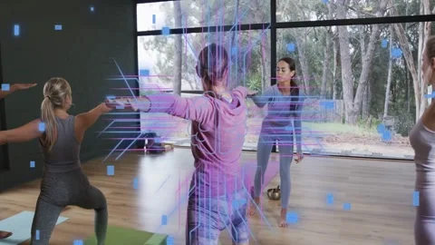 Central yogi holding warrior pose in yoga studio teacher cueing holo code Stock Footage 333105385