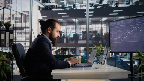 CEO analyzing and evaluating company data reports on tablet and laptop Stock Photos