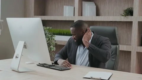 CEO gets neck problems at workplace. African American in a business suit Office Stock Footage 170659668