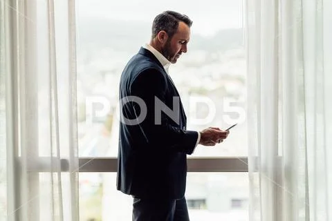 CEO using mobile phone in hotel room Stock Photos
